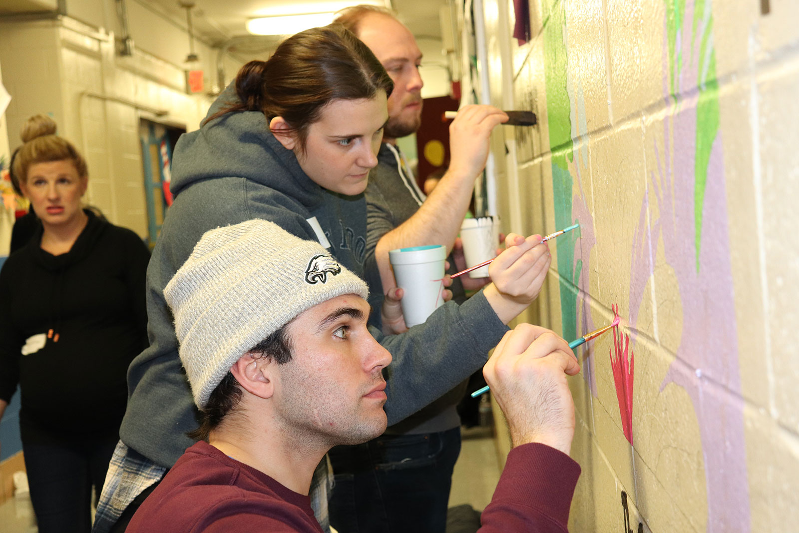 DMi MLK Day volunteering at Stephen Girard Elementary School, dmi employees painting a brightly colored wall
