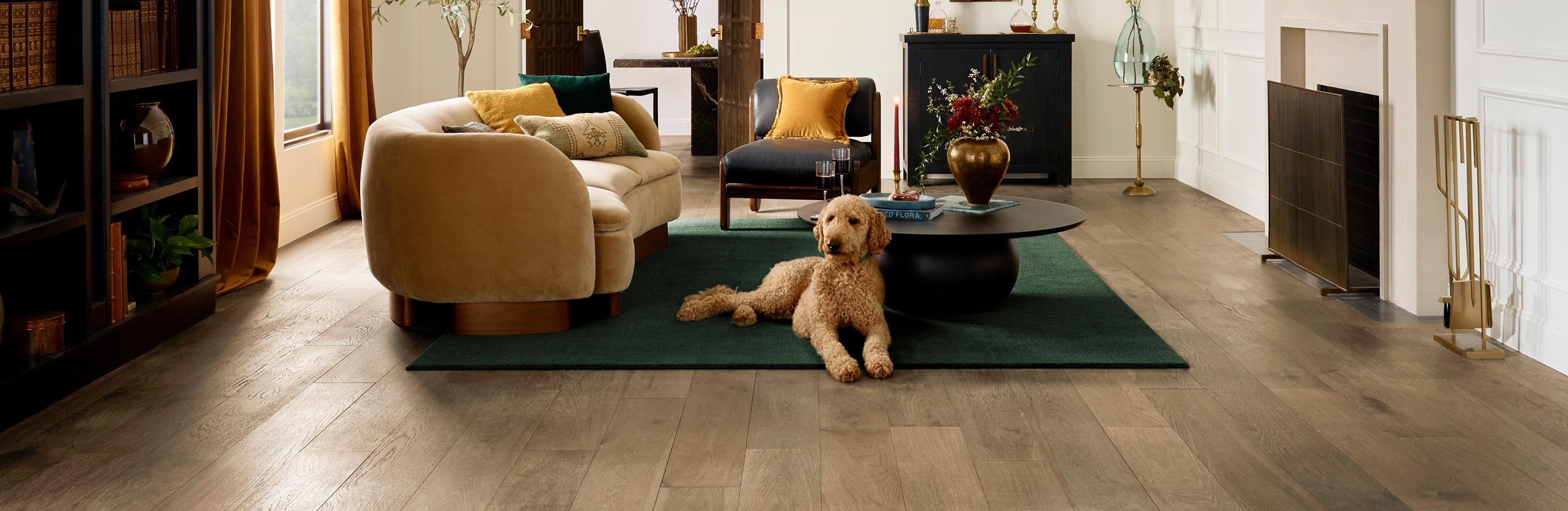 Light brown wood-look flooring in a modern living room with neutral furniture and green area rug